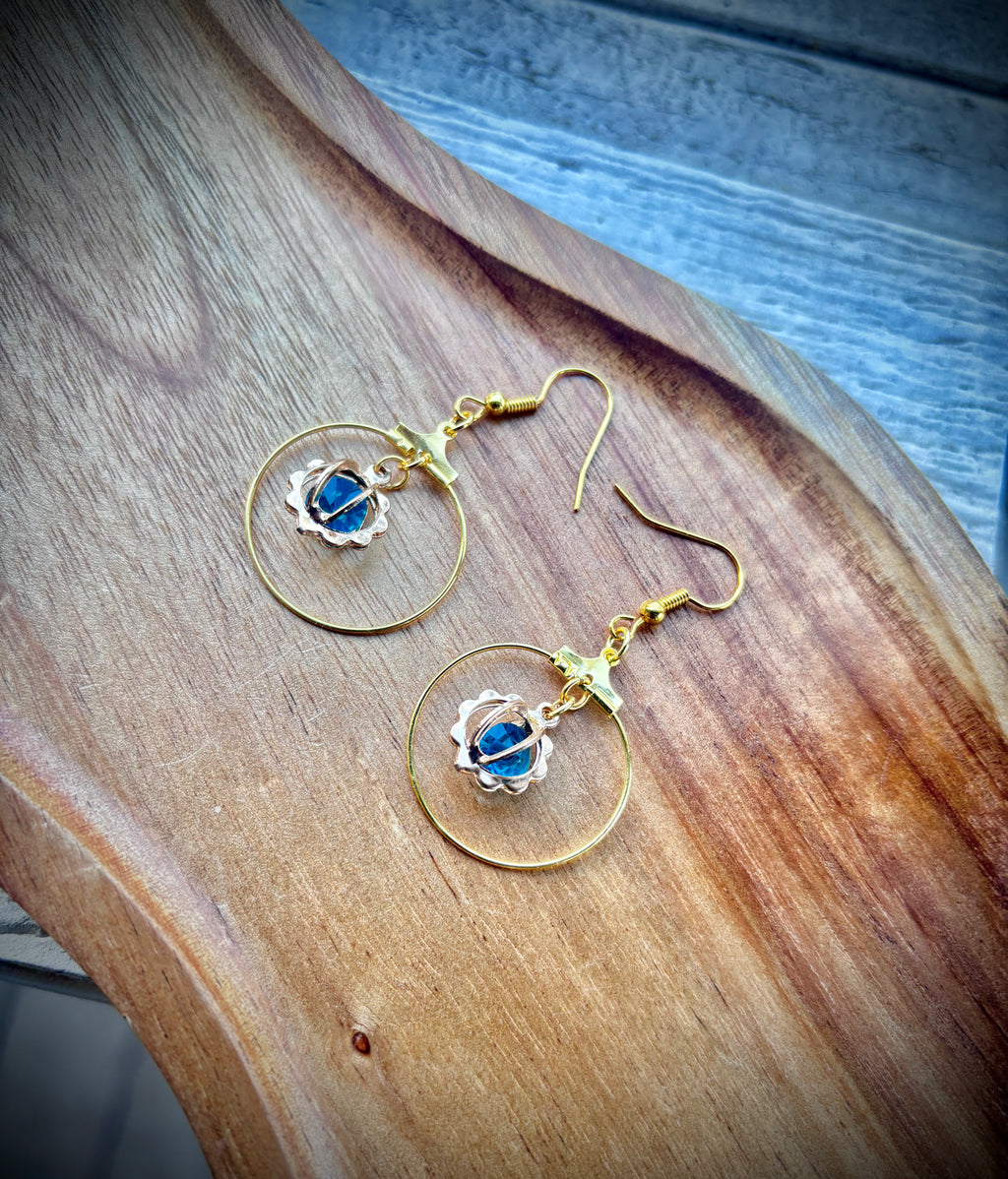 Gold tone hoop earrings with blue gem